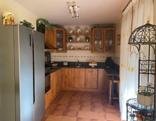 een keuken met houten kasten en een koelkast bij El Balcon de Villapresente in Villapresente