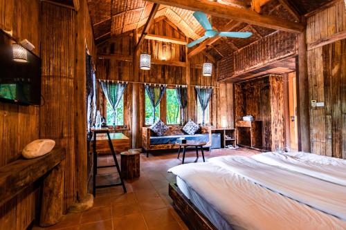 a bedroom with a bed in a room with wooden walls at Sapa Riverside Ecolodge & Spa in Sa Pa