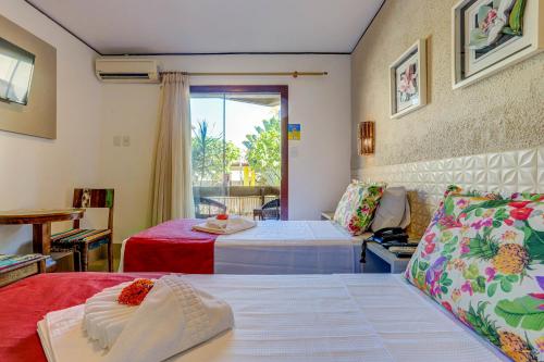 a hotel room with two beds and a couch at Pousada Praia Bela in Ilhéus