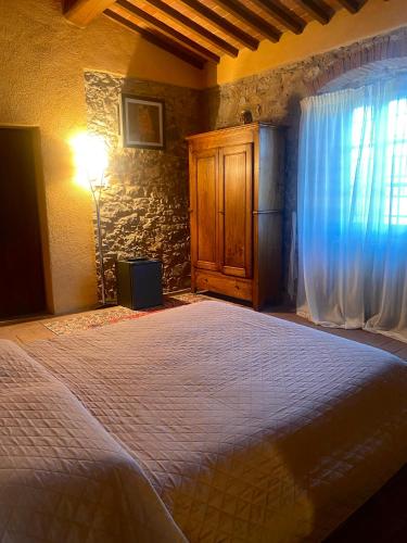 a bedroom with a large bed and a window at Room in BB - Sottotono Agriturismo with swimming pool on Florence surrounded by greenery in Carmignano