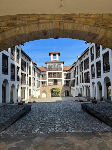 an empty courtyard with a large building in the background at Къща за гости Геша Вю in Dryanovo