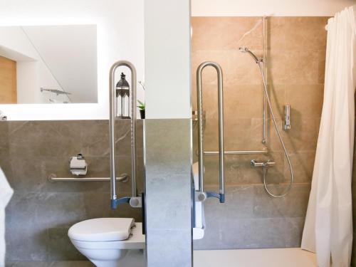 a bathroom with a shower and a toilet and a sink at stettli resort in Parpan