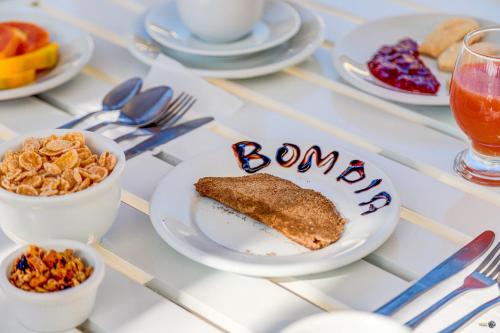a table with a plate of food with the word bonus at Pousada Praia Bela in Ilhéus