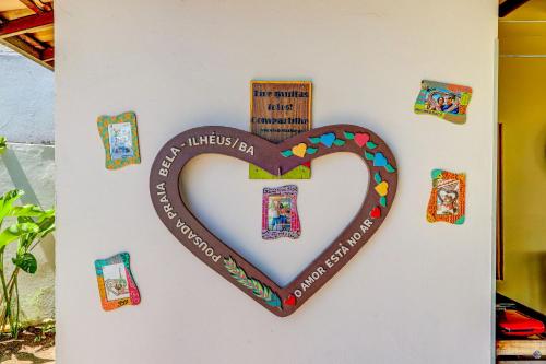 a heart shaped sign on a wall with a cross at Pousada Praia Bela in Ilhéus