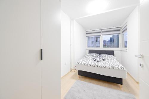 een slaapkamer met een bed en een raam bij Apartment UNA Alipasino with two bedrooms in Sarajevo