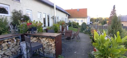 einen Garten mit einem Tisch und Stühlen sowie ein Gebäude in der Unterkunft Ferienwohnung Alter Kräuterhof in Mildenau