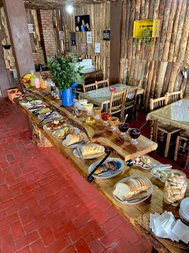 een lange tafel met borden met eten erop bij Cabanas Imbuia in Cambará
