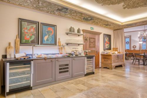 a kitchen with gray cabinets and a dining room at Hotel Eisenhut in Rothenburg ob der Tauber