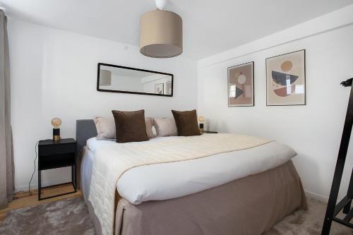 Schlafzimmer mit einem Bett und einem Wandspiegel in der Unterkunft Sanders Regent - Lovely Two-Bedroom Apartment Near Central Square in Kopenhagen