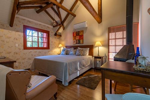 a bedroom with a bed and a desk and a window at Pousada Vila 505 in Canela