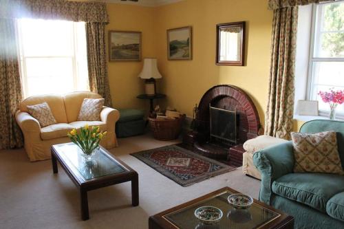 a living room with a couch and a fireplace at St Marys Farmhouse - Traditional Country Farmhouse with Open Fire in Fochabers