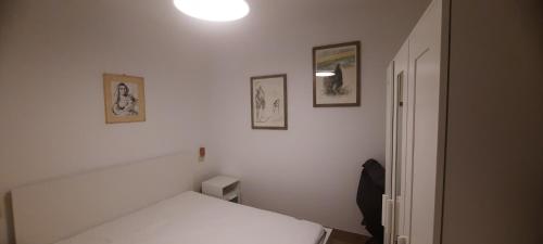a bedroom with a bed and three pictures on the wall at Casa del nonno Gino in Pietrasanta
