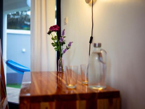 a table with two glasses and a vase with flowers at homeland bro in Dar es Salaam