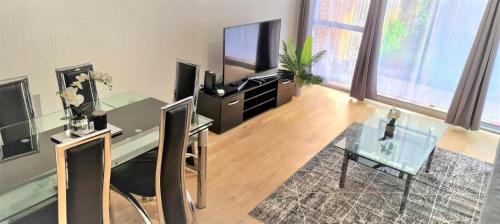 a living room with a glass table and a television at Parkway in London Colney
