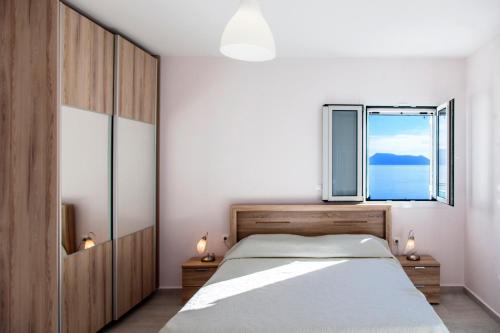 a bedroom with a large bed and a window at Panorama Ionian View in Nikiana