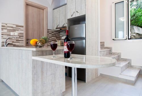 a kitchen with a table with two glasses of wine at Panorama Ionian View in Nikiana