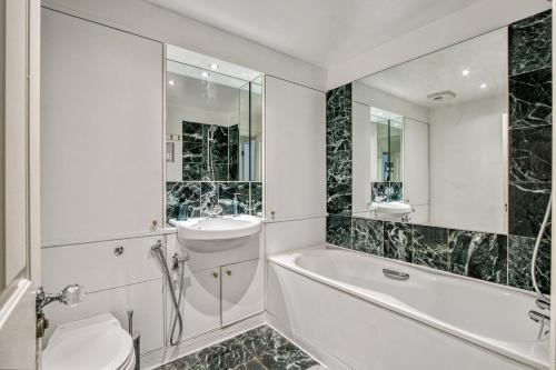 y baño con bañera, lavabo y aseo. en 2-Bed 2-Bathroom Mayfair - Maddox St en Londres