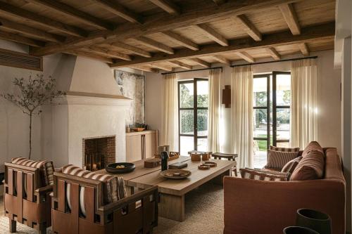 a living room with a table and chairs and a fireplace at Magnifique villa dans propriété au havre de paix in Le Plan-de-la-Tour