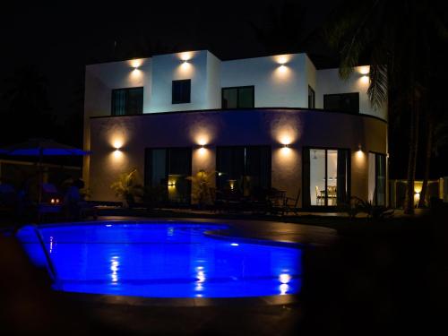 a blue pool in front of a house at night at homeland bro in Dar es Salaam