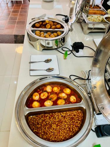 a buffet with two trays of food on a counter at Hotel Totara in Dar es Salaam