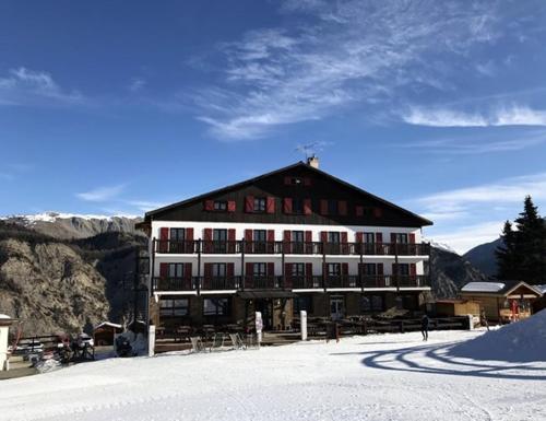 a large building on top of a snow covered mountain at Chalet Sainte Anne in Condamine-Châtelard