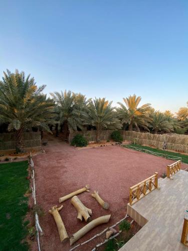 a garden with logs in the middle of a park at كوخ آفيري Aviary Hut in AlUla