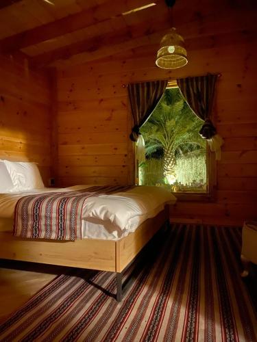a bedroom with a bed in a log cabin at كوخ آفيري Aviary Hut in AlUla