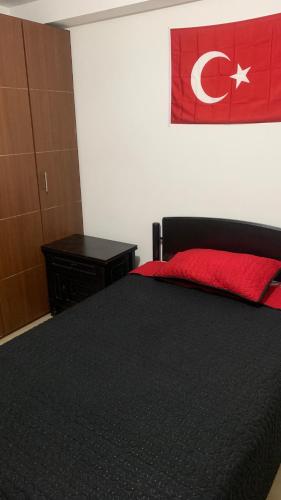 a bedroom with a black bed with a red pillow at Apartamento amoblado nuevo in Pereira