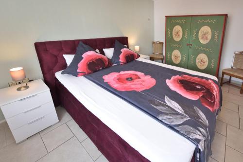 a bedroom with a bed with red flowers on it at Haus Wegener in Bad Sassendorf