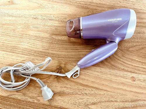 a purple hair dryer on a wooden table at Ukishima bldg in Makishimachi