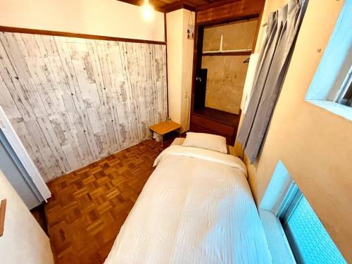 a small bedroom with two beds and a window at Ukishima bldg in Makishimachi