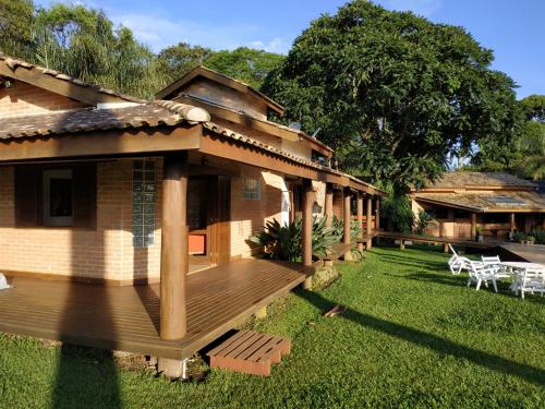 a house with a wooden deck in the yard at Contempla Joanópolis in Joanópolis