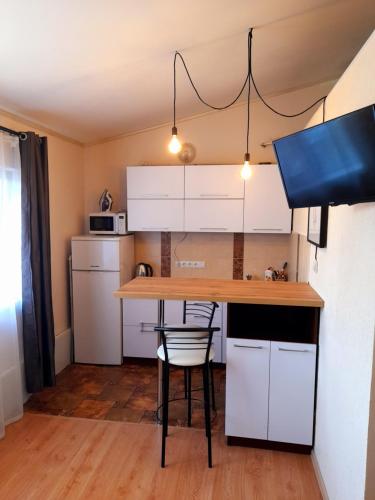 una cucina con tavolo e alcuni armadietti bianchi di Studio apartments in center MINI 5/5 a Ivano-Frankivsʼk