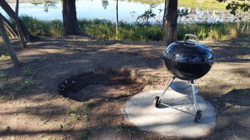 a charcoal grill sitting on a stand in a field at The Farmers Lodge in Thorndale