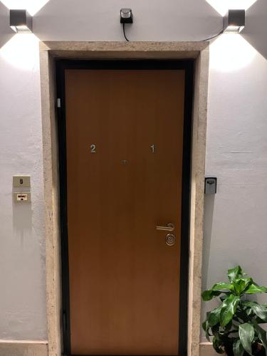 a brown door in a building with a plant at Minardi Apartments in Vercelli