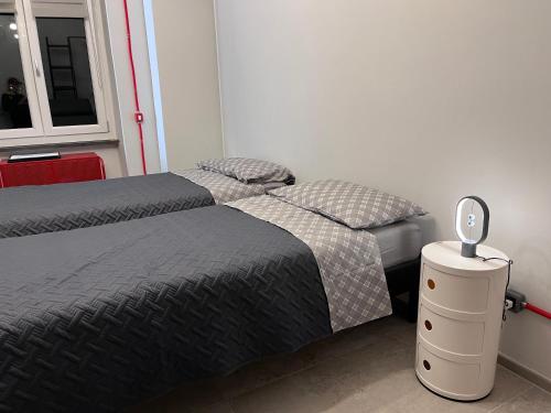 a bedroom with two beds and a lamp on a night stand at Minardi Apartments in Vercelli