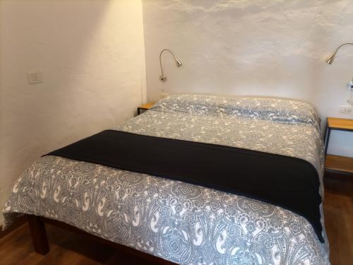 2 bedden in een kleine kamer met een nachtrok bij El Sueño: un lugar especial para sus vacaciones in Fuencaliente de la Palma