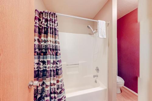 a bathroom with a shower curtain and a toilet at Chalet Village #24 in Brian Head