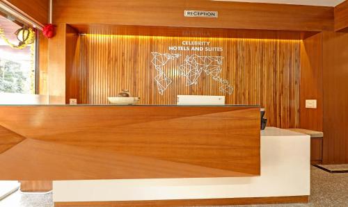 a lobby with a reception desk with a sign on the wall at Treebo Celebrity Hotels And Suites in Bengaluru