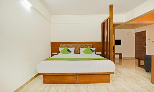 a bedroom with a large bed and a television at Treebo Celebrity Hotels And Suites in Bengaluru