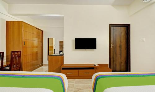 a bedroom with two beds and a flat screen tv at Treebo Celebrity Hotels And Suites in Bengaluru