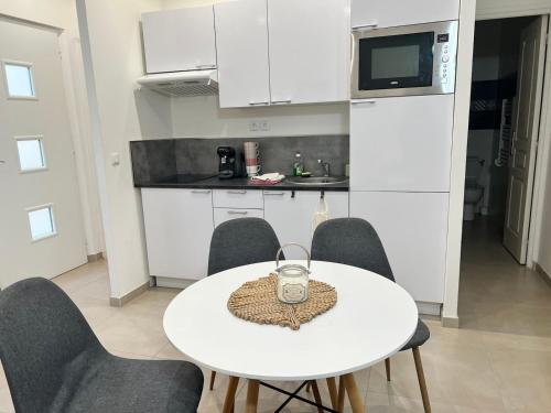 une cuisine blanche avec une table et des chaises blanches dans l'établissement le petit sémaphore, à Saint-Raphaël