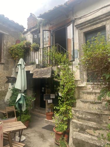 an outdoor patio with a table and an umbrella at La Casa sui Tetti -Calcata in Calcata