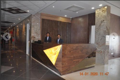 two men are standing in the lobby of a building at Meridian Hotel & Banquet in Surat