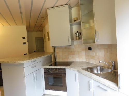 a kitchen with white cabinets and a sink at Baita Li Selucia in Livigno