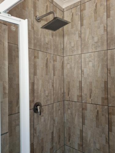 a shower with a glass door and a shower head at Sea Casa in Scottburgh