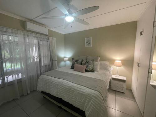 a bedroom with a bed with a ceiling fan at Sea Casa in Scottburgh