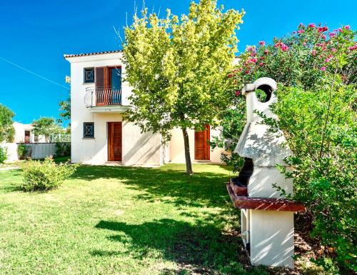 een standbeeld van een vrouw op een bankje voor een huis bij Graziosi appartamenti a Budoni con aria condizionata a soli 300 mt dal mare in Budoni