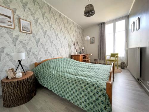 - une chambre avec un lit et une couverture verte dans l'établissement Le Neufchâtel appartement cosy 3 chambres, à Reims