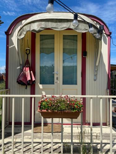 a house with a porch with a flower pot on a fence at La vagabonde in Gesves